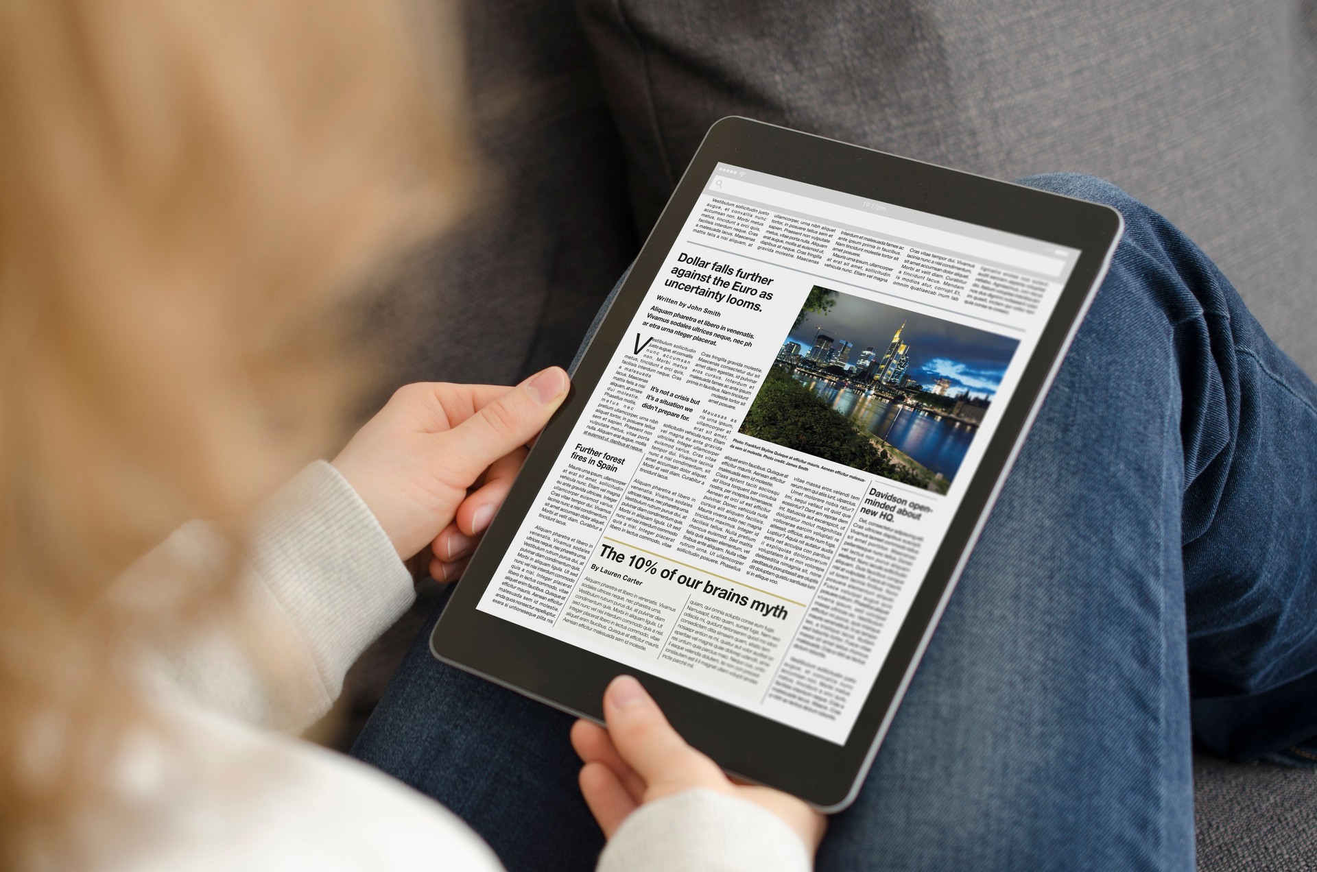 Young woman reading the news article on a modern tablet computer