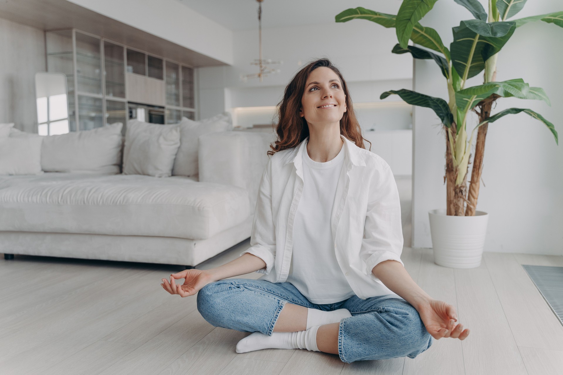 Peace of mind and mental health concept. Young european woman practicing yoga on floor and smiling.