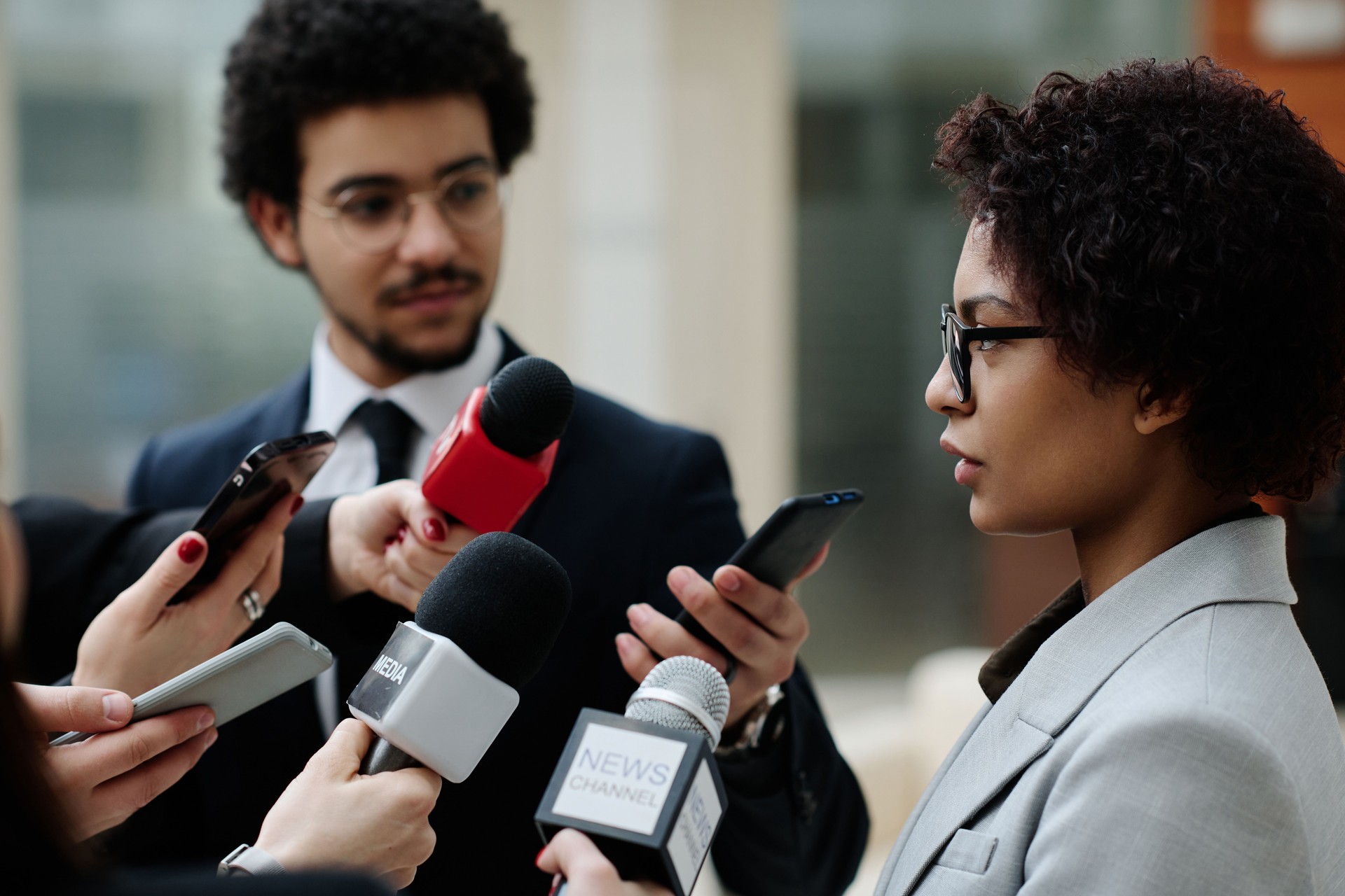 Businesswoman talking to reporters at conference